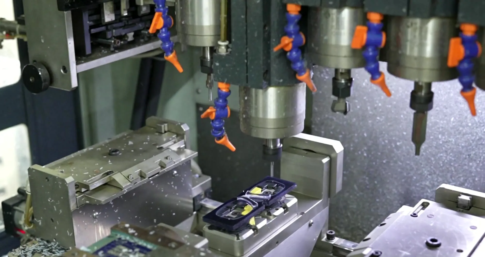 A CNC machine cutting a cellulose acetate frame front at the Rushabh Trading Company factory